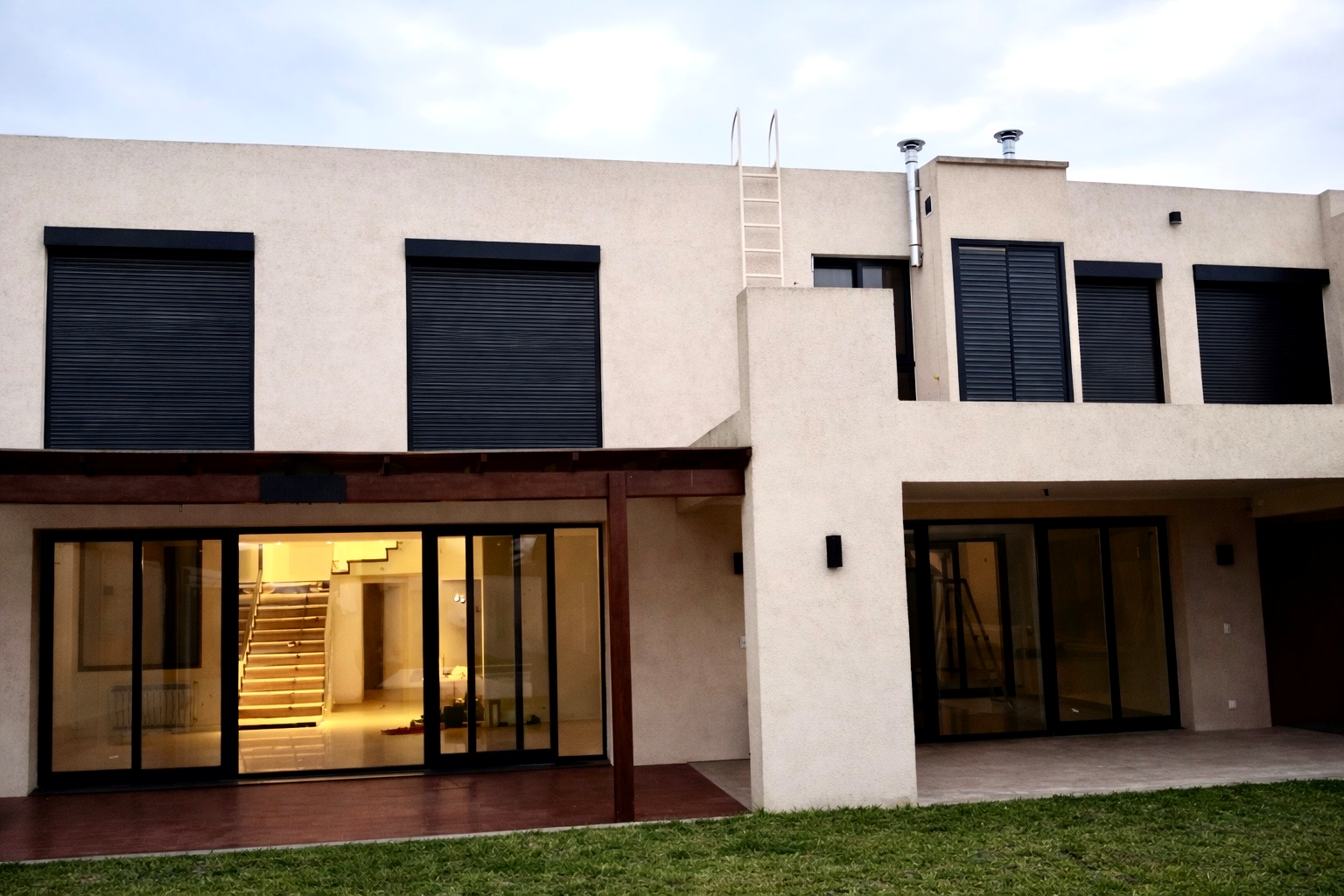 Residencia con ventanales y persianas eléctricas