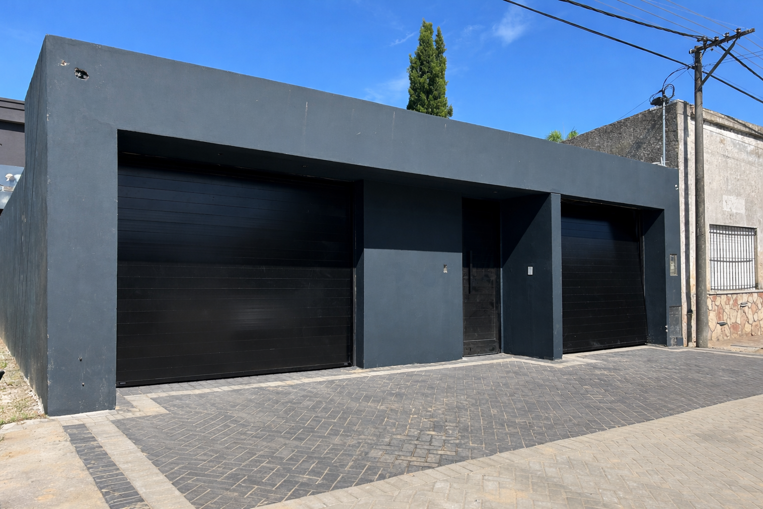 Fachada con portones automáticos negros